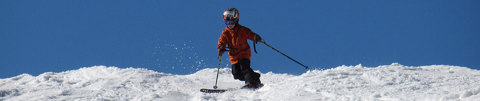 An image of Ty Telemark skiing in spring snow on the Ridge View Trail at Stowe Mountain Resort in Vermont