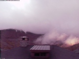 An image of early October snowfall being revealed on the slopes of Mt. Mansfield in Vermont as the clouds begin to lift