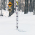 An image showing a snow measurement pole with a reading of more that two feet of powder on the ridgeline to the west of Bolton Valley in Vermont