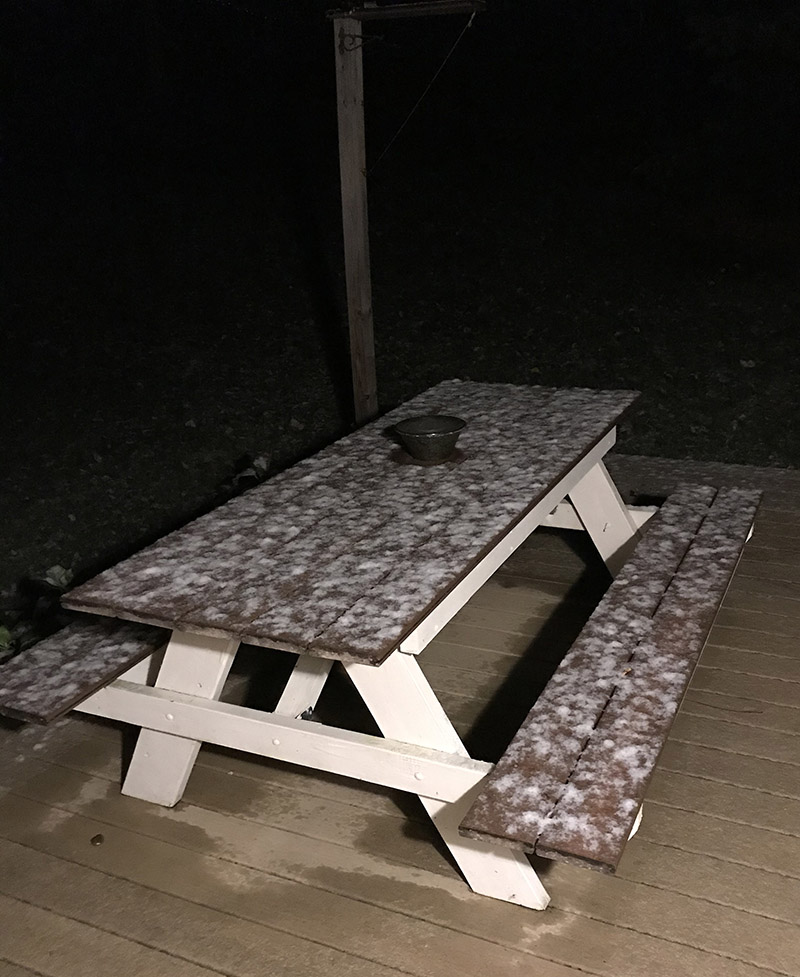 An image of October snow on a picnic table in Waterbury, Vermont