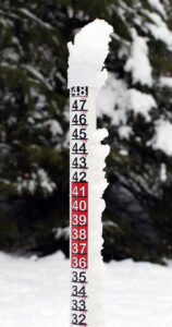 An image of a snow depth measurement stake in Waterbury Vermont with delicate upslope snow sticking to the top and sides of the stake