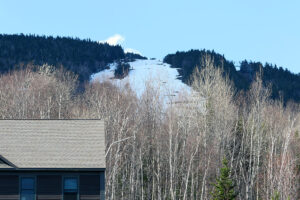 An image looking up from the Mountain Mansfield Ski Academy lodge parking lot toward the Main Street trail on Spruce Peak at Stowe Mountain Ski Resort in Vermont