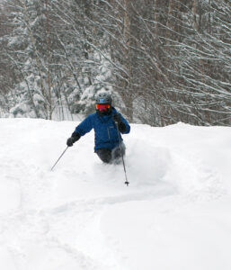 An image of Erica skiing powder on the Tattle Tale trail during Winter Storm Landon at Bolton Valley Resort in Vermont