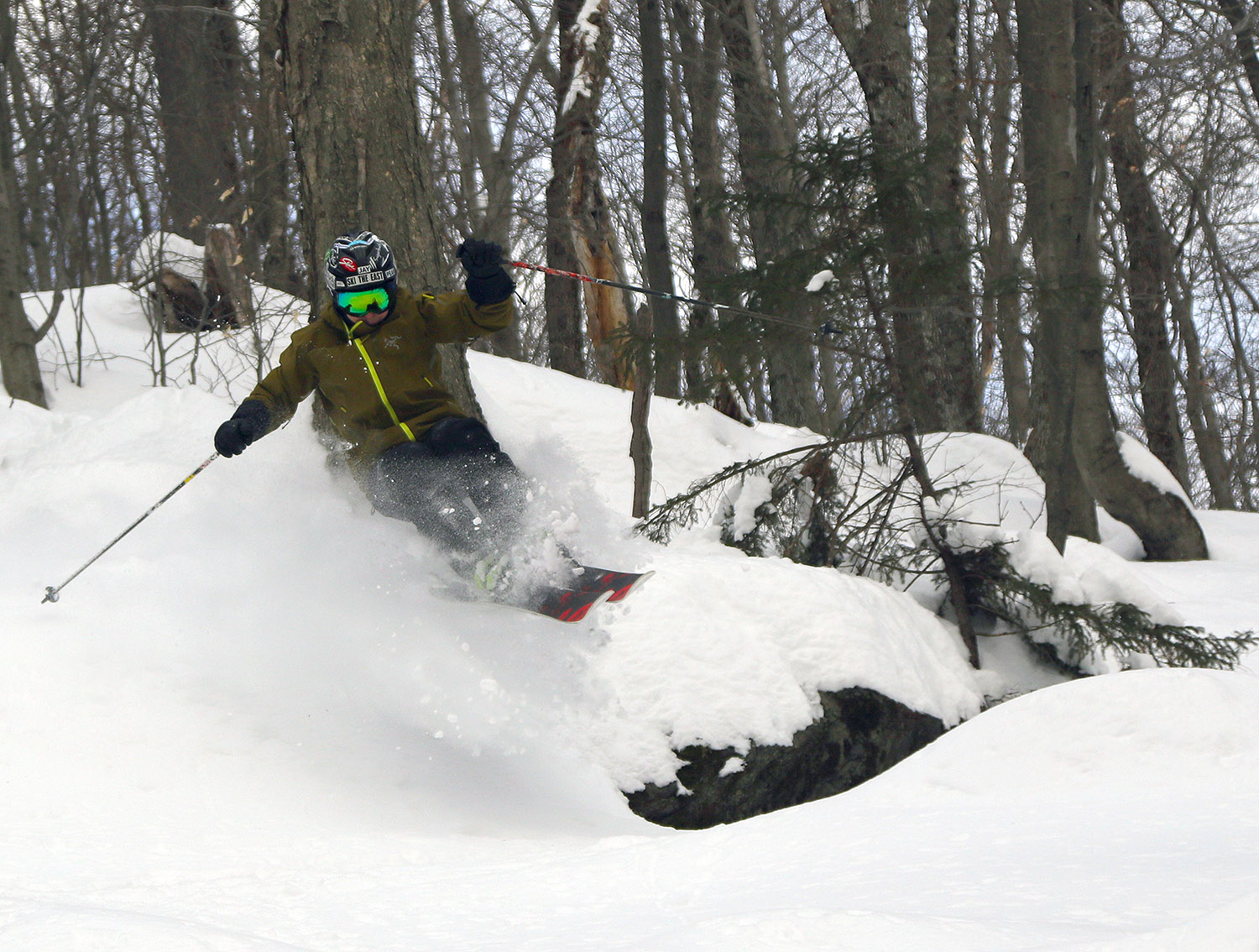 An image of Jay catching some air while skiing among the powder left over from Winter Storm Landon in the Doug's Knob area of Bolton Valley Ski Resort in Vermont