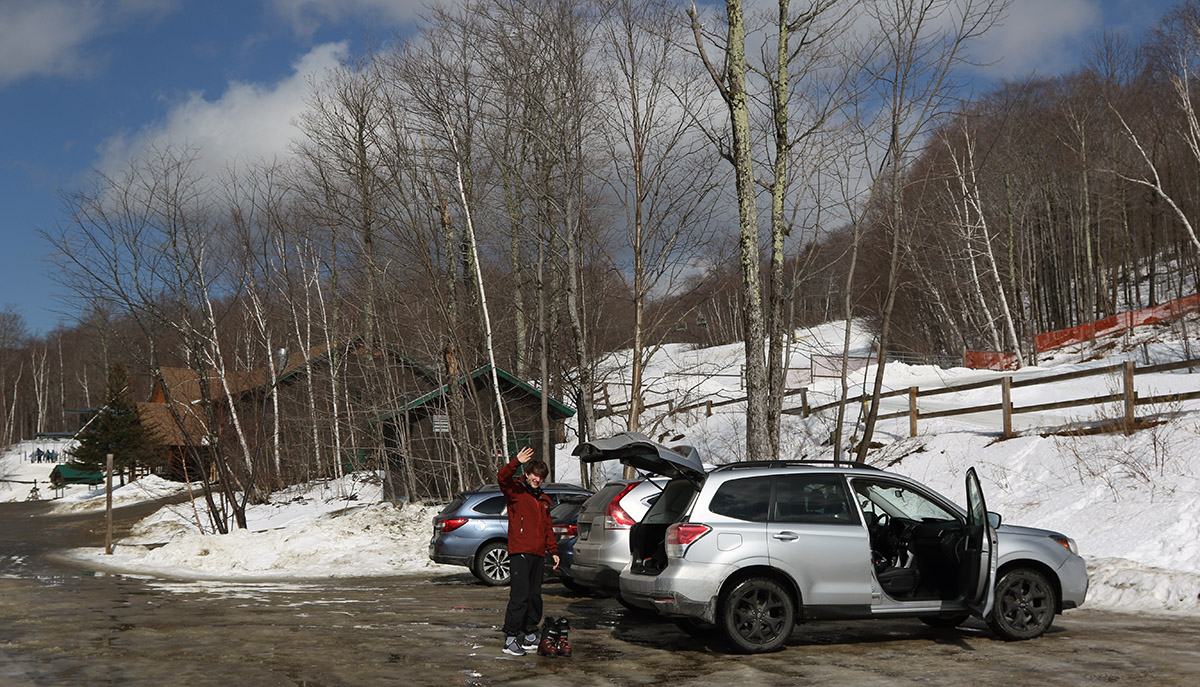 An image of a few cars on a spring day in the uppermost parking lot at the Timberline area of Bolton Valley Ski Resort in Vermont