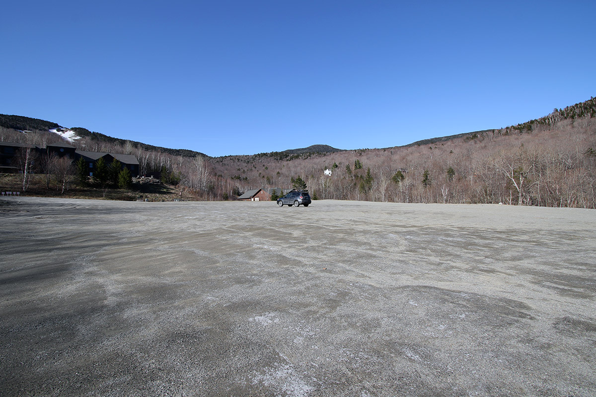 An image of a single car in the parking lot of the Mount Mansfield Ski Club during a May ski outing at Stowe Mountain Ski Resort in Vermont