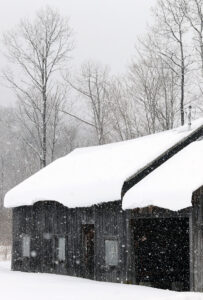 An image of a building covered in snow with snow falling in January in the Nebraska Valley of Vermont