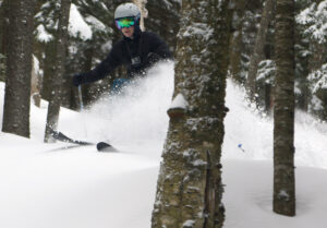 An image of Colin spraying powder while skiing in the trees during Winter Storm Quest at Bolton Valley Ski Resort in Vermont