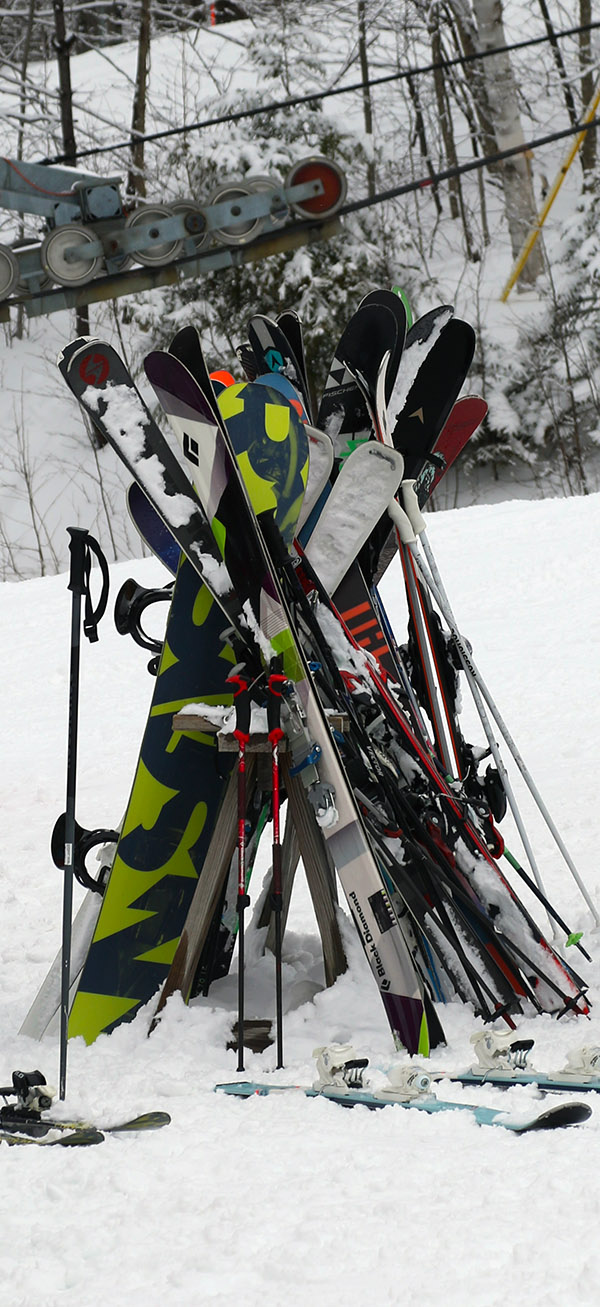 An image showing skis on a ski rack outside the Timberline Base Lodge at Bolton Valley Resort in Vermont
