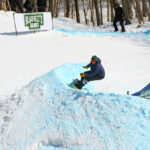 An image of a snowboarder in a turn facing the camera at the Blauvelt's Banks competition at Bolton Valley Ski Resort in Vermont