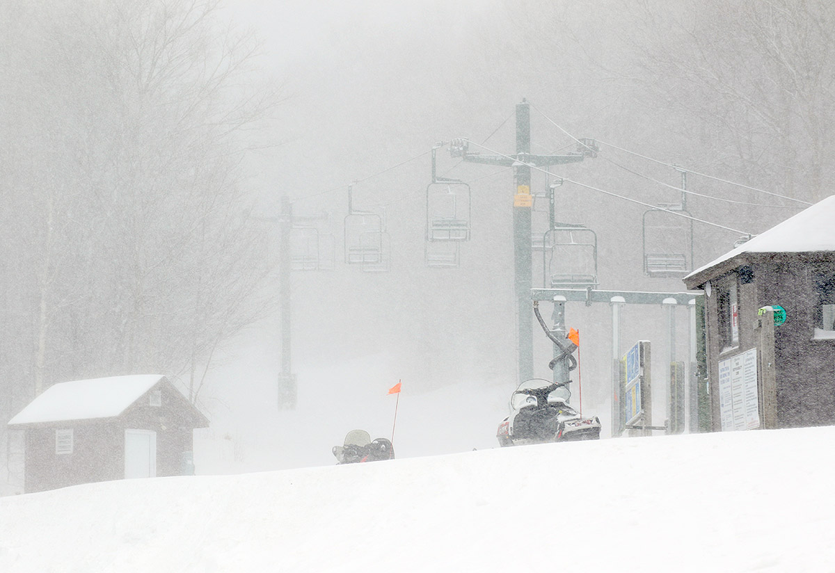 An image of the base of the Wilderness Double Chairlift with heavy winds and snowfall during Winter Storm Olive at Bolton Valley Ski Resort in Vermont