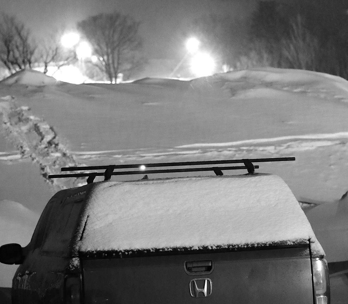 An image of a snowbank with night skiing lights in the background during Winter Storm Uriel at Bolton Valley Ski Resort in Vermont