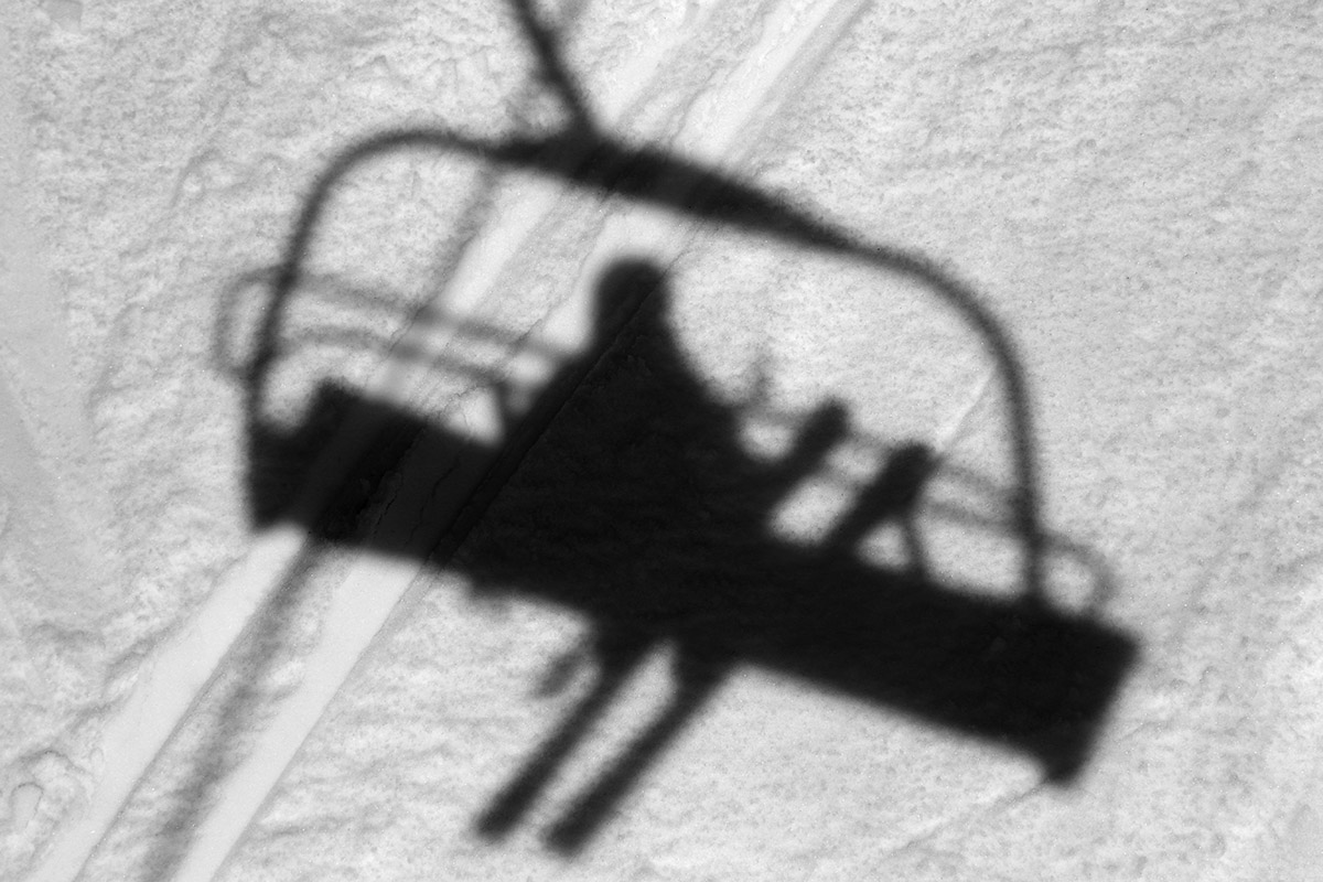 An image showing a shadow of a skier on the Timberline Quad Chairlift at Bolton Valley Ski Resort in Vermont