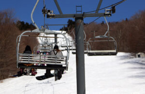 An image of skiers riding the Timberline Quad Chairlift at Bolton Valley Ski Resort in Vermont