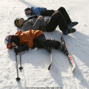 An image of Dave and the boys laying on the snow