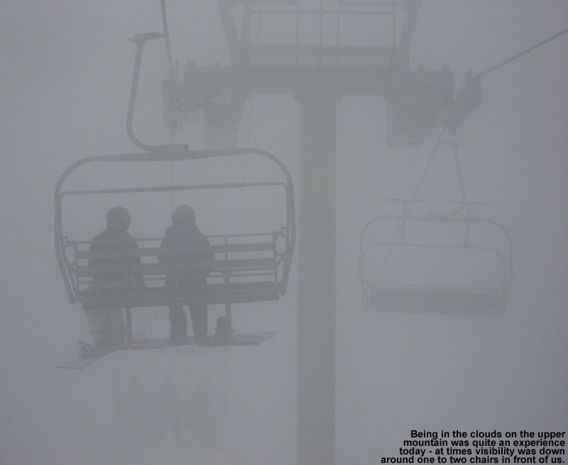 An image of snowboarders riding the Vista Quad Chair in heavy fog at Bolton Valley Ski Resort in Vermont