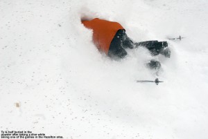 An image of Ty half buried in powder in one of the gullies in the Hazelton Zone at Stowe Mountain Ski Resort in Vermont