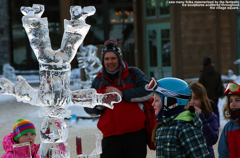 An image of an ice sculpture and onlookers  in the middle of the Spruce Peak Village at Stowe Ski Resort in Vermont