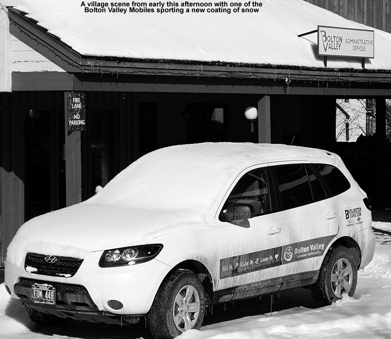 An image of one of the Bolton Valley resort vehicles in the village circle with a coating of snow