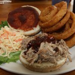 An image of the pulled pork sanwich along with coleslaw and onion rings at the James Moore Taver at Bolton Valley Ski Resort in Vermont
