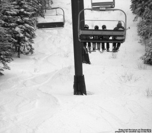 An image of Greg and some of the boys in our ski group on the Sensation Quad at Stowe Mountain Resort, with tracks visible in the powder on the lift line trail below