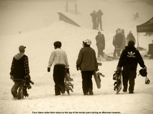 An image of four snowboarders walking up for another run in the terrain park at Stowe - March 25, 2012