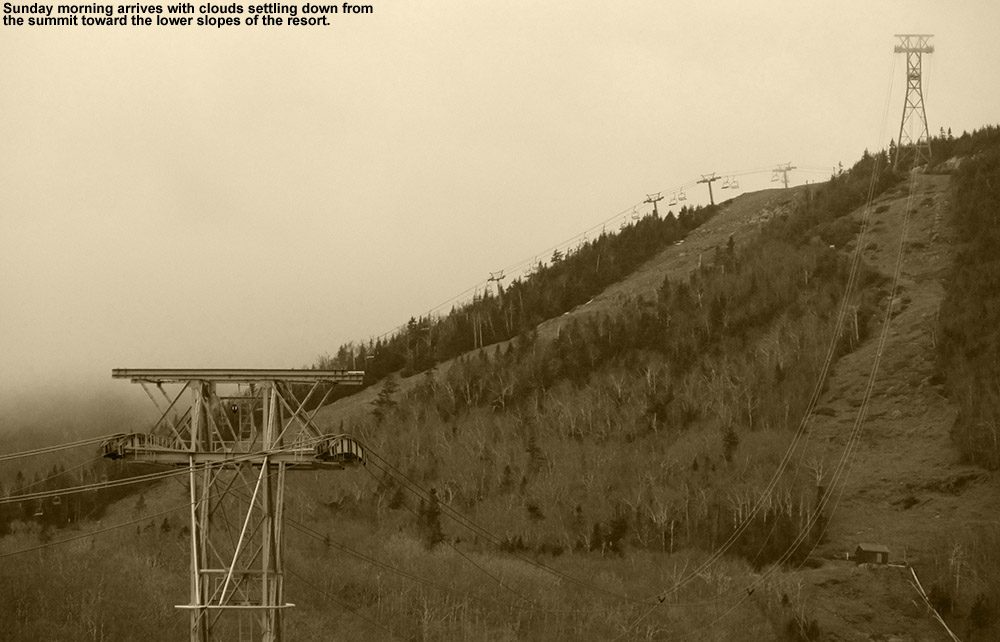 An image of tram and chairlift towers under descending clouds from the tram base area at Jay Peak Ski Resort in Vermont