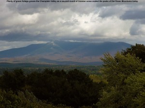 An image showing Vermont's second October snowfall coating the summit of Mt. Mansfield, with green trees in the Champlain Valley marking the foreground