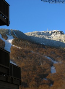 An image of balconies of the Stowe Mountain Lodge at Stowe Mountain Ski Resort in Vermont, with the Nose area of Mt. Mansfield in the background under blue skies
