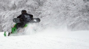 An image of skiers using a snowmobile to ski laps on terrain at Bolton Valley Ski Resort in Vermont 