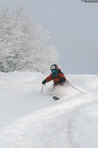 An image of Ty Telemark skiing in powder on the headwall of the Showtime trail at Bolton Valley Ski Resort in Vermont