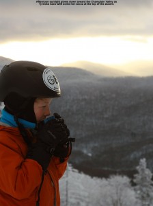 An image of Ty drinking hot cocoa at the Timberline Mid Station at Bolton Valley Ski Resort in Vermont, with late day light peeking through the clouds in the background
