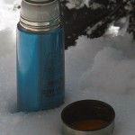 An image of a thermos and cup sitting in powder snow outside the Bryant Lodge on the backcountry trail network at Bolton Valley Ski Resort in Vermont