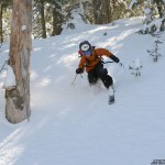 An image of Ty Telemark skiing in powder of the back side of  Bolton Valley Resort
