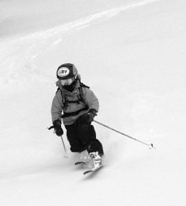 A black and white image of Ty Telemark skiing in powder on the Wilderness Lift Line trail at Bolton Valley Resort in Vermont
