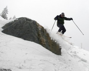 An image of Ken jumping off a rock on skis into the powder above Green Acres at Stowe Mountain Resort in Vermont