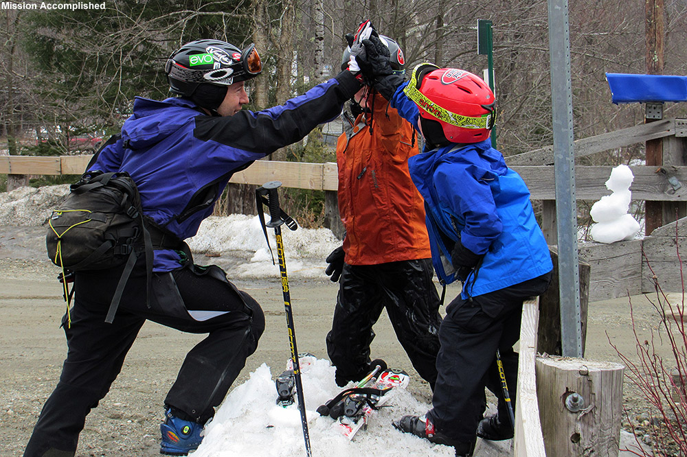 An image of Jay, Ty, and Dylan giving each other a "high five" near the Matterhorn in Stowe, Vermont after finishing off a run of the Bruce backcountry ski trail