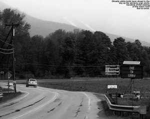 An image of ski trails and a status sign for Route 108 through Smuggler's Notch in Vermont indicating that the notch road was closed due to snow over Memorial Day Weekend