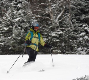 An image of Erica skiing in powder on the Perry Merrill trail at Stowe Mountain Resort in Vermont after some October snow