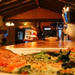 An image of a slice of pizza and the bar at the Fireside Flatbread restaurant at Bolton Valley Ski Resort in Vermont