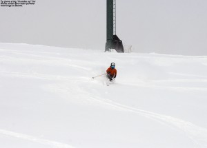 An image of Ty skiing powder in the open terrain above the Meadows trail at Stowe Mountain Resort in Vermont