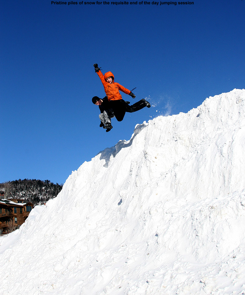 An image of Ty and Dylan jumping off a large snow pile at Stowe Mountain Ski Resort in Vermont