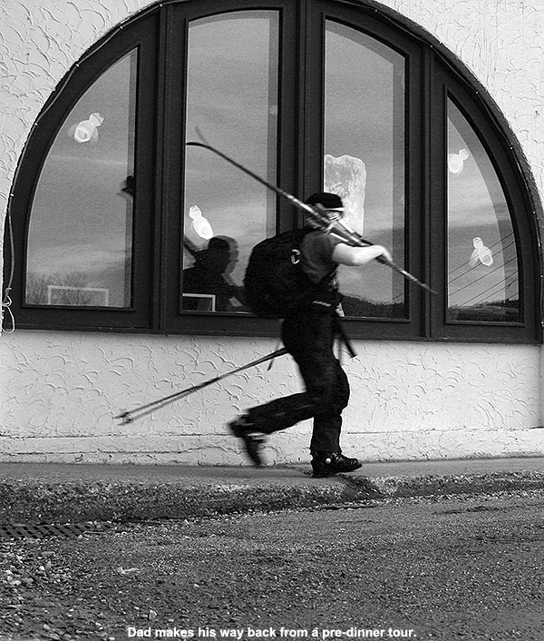 An image of Jay walking with Telemark skis in front of the base lodge at Jay Peak Ski Resort in Vermont