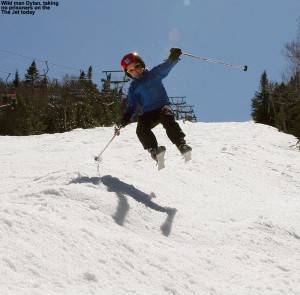 An image of Dylan jumping in the air on skis on the Jet Trail at Jay Peak Resort in Vermont