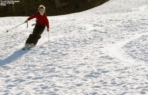 An image of Ty skiing in spring snow on the North Slope trail at Stowe Mountain Resort in Vermont in mid May 