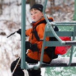 An image of Dylan sitting on the closed Wilderness Double Chairlift at the start of a ski tour at Bolton Valley Ski Resort in Vermont