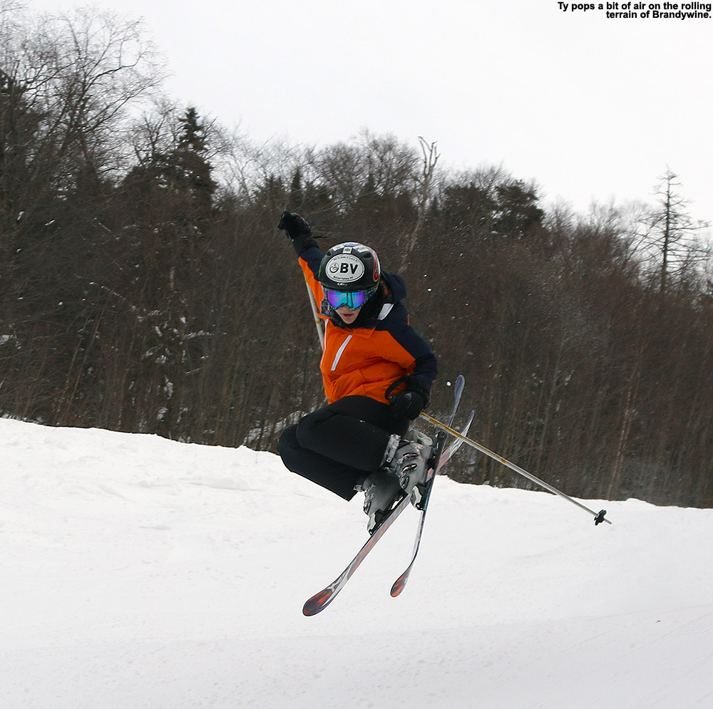 An image of Ty doing a jump on skis on the Brandywine trail at Bolton Valley Ski Resort in Vermont