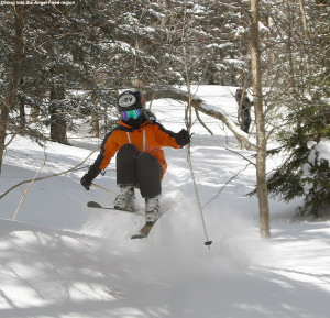 An image of Ty doing a jump while skiing powder at Stowe Mountain Resort in Vermont