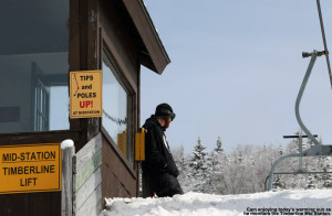An image of a lift attendant watching the chairs pass by on the Bolton Valley Timberline Mid Station