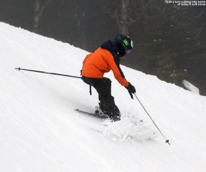 An image of Ty carving a turn and pushing some soft snow on the Liftline trail at Stowe Mountain Resort in Vermont
